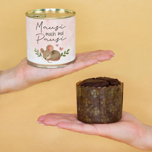 Kompakter Dosenkuchen „Mausi mach mal Pausi“ auf einer Hand neben ausgepacktem Brownie zur Größenansicht