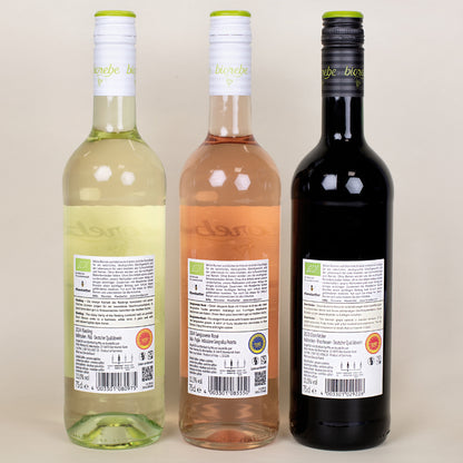 Rückseiten der drei Biorebe-Weinflaschen Riesling, Sangiovese Rosé und Dornfelder mit Etiketten und Inhaltsangaben