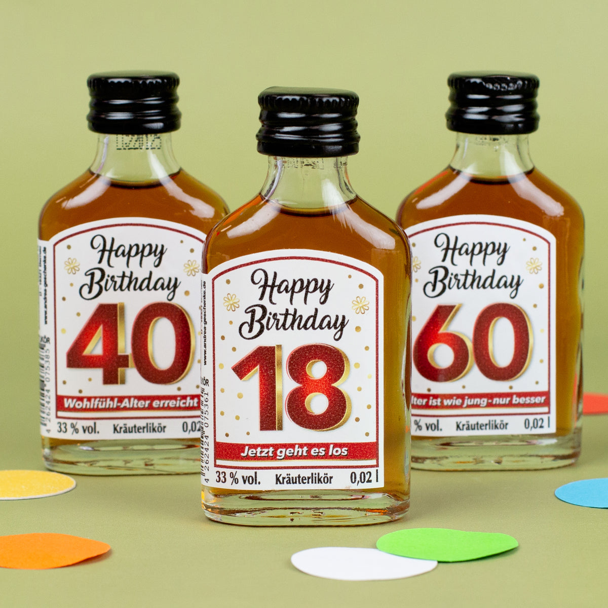 Drei Mini-Kräuterliköre mit Etiketten „Happy Birthday 18“, „40 – Wohlfühl-Alter erreicht“ und „60 – Alter ist wie jung – nur besser“