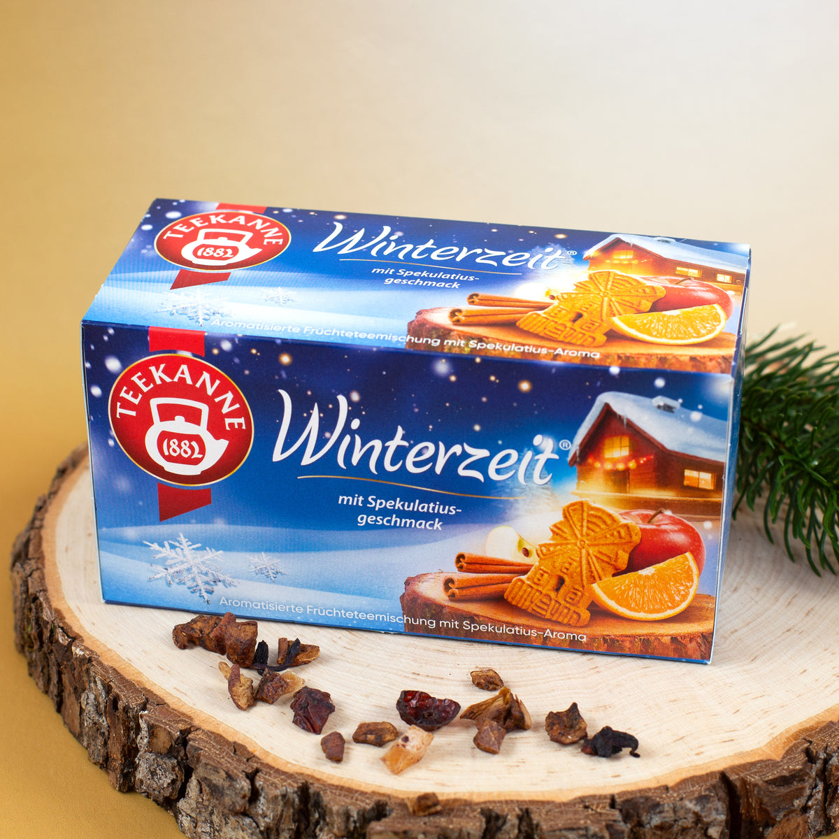Teekanne Winterzeit Früchtetee mit Spekulatiusgeschmack auf Holzscheibe mit winterlicher Dekoration