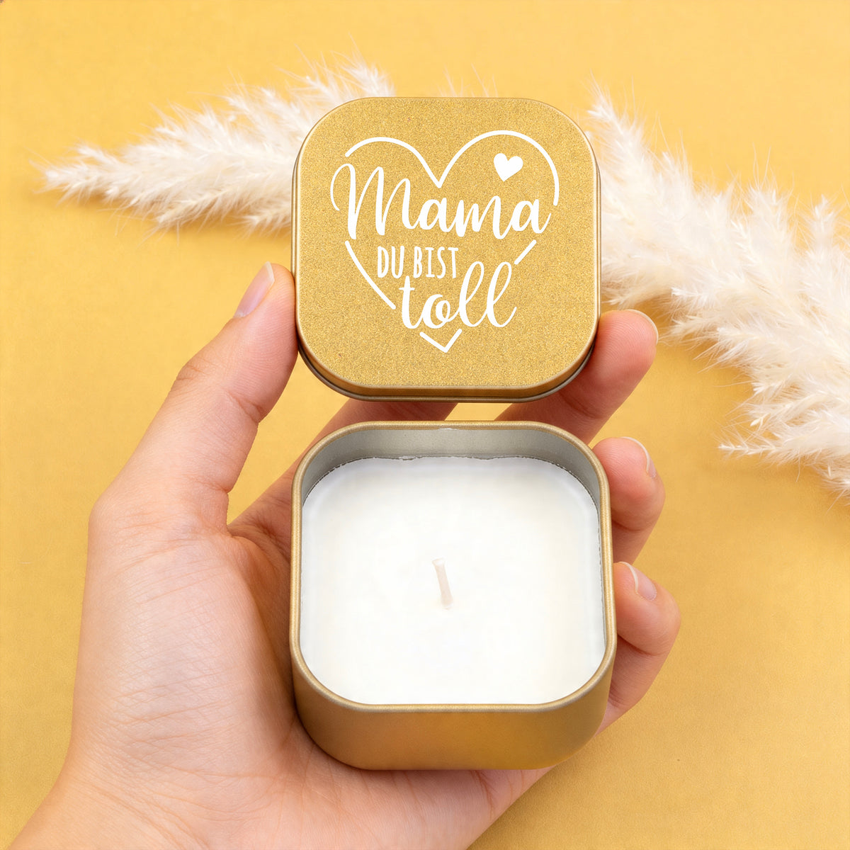 Geöffnete goldene Metallkerze mit Deckel in der Hand, Motiv „Mama du bist toll“