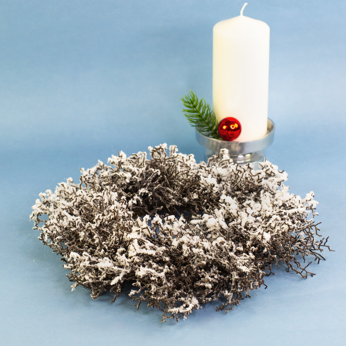 Schneezweig-Adventskranz mit weißer Stumpenkerze und Tannenzweig-Dekoration