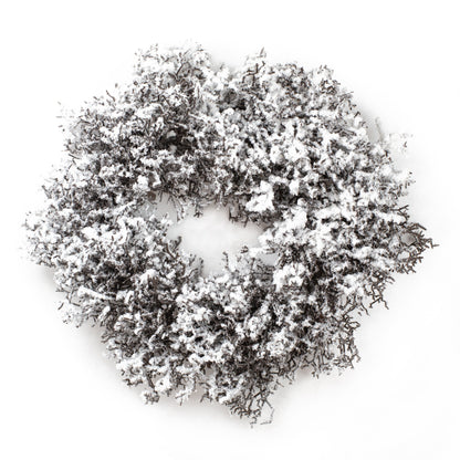 Winterlicher Kranz aus Kunstzweigen mit Schneeschicht als Weihnachtsdekoration