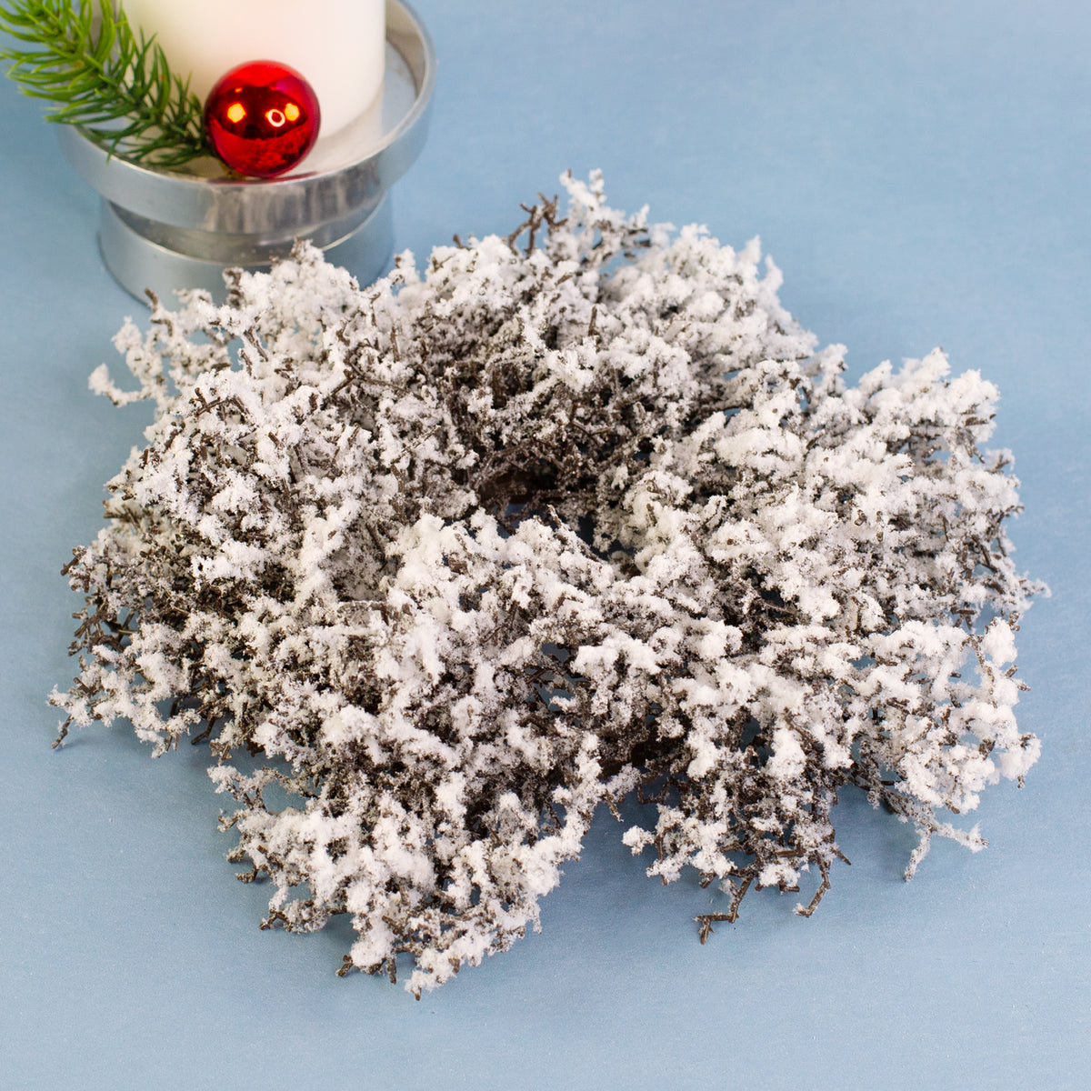Kleiner künstlicher Adventskranz aus Schneezweigen mit realistischem Schnee-Effekt – ideal als Tischdeko oder Kerzenständer.