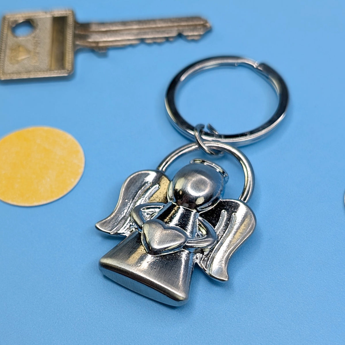 Detailaufnahme des Schlüsselanhängers Engel mit Herz, Fokus auf die Form und Struktur der Figur