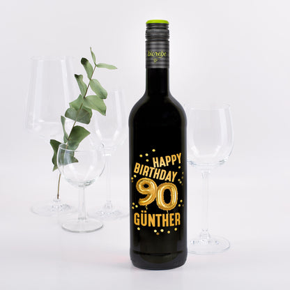 Rotweinflasche mit goldenem „Happy Birthday 90 Günther“-Aufdruck und Ballon-Design, dekoriert mit Gläsern und Eukalyptus