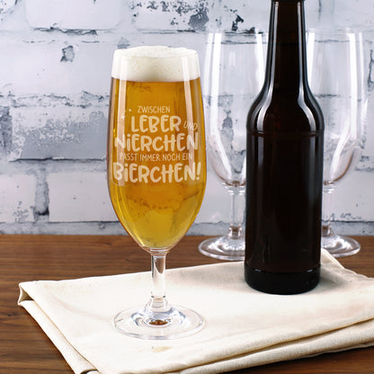Bierglas mit Gravur "Zwischen Leber und Nierchen..." vor heller Backsteinwand