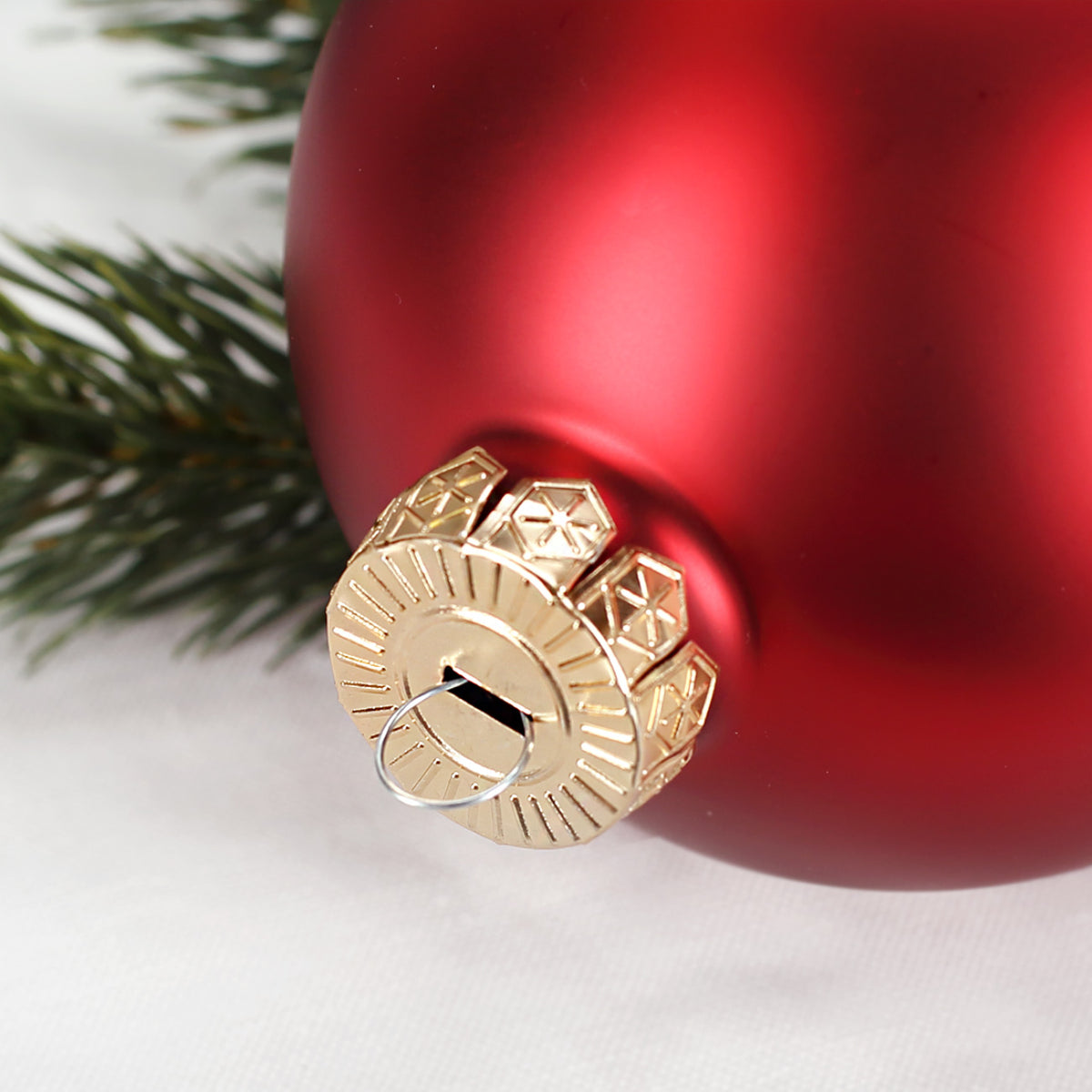 Detailfoto der roten glänzenden Weihnachtskugel mit goldener Aufhängung