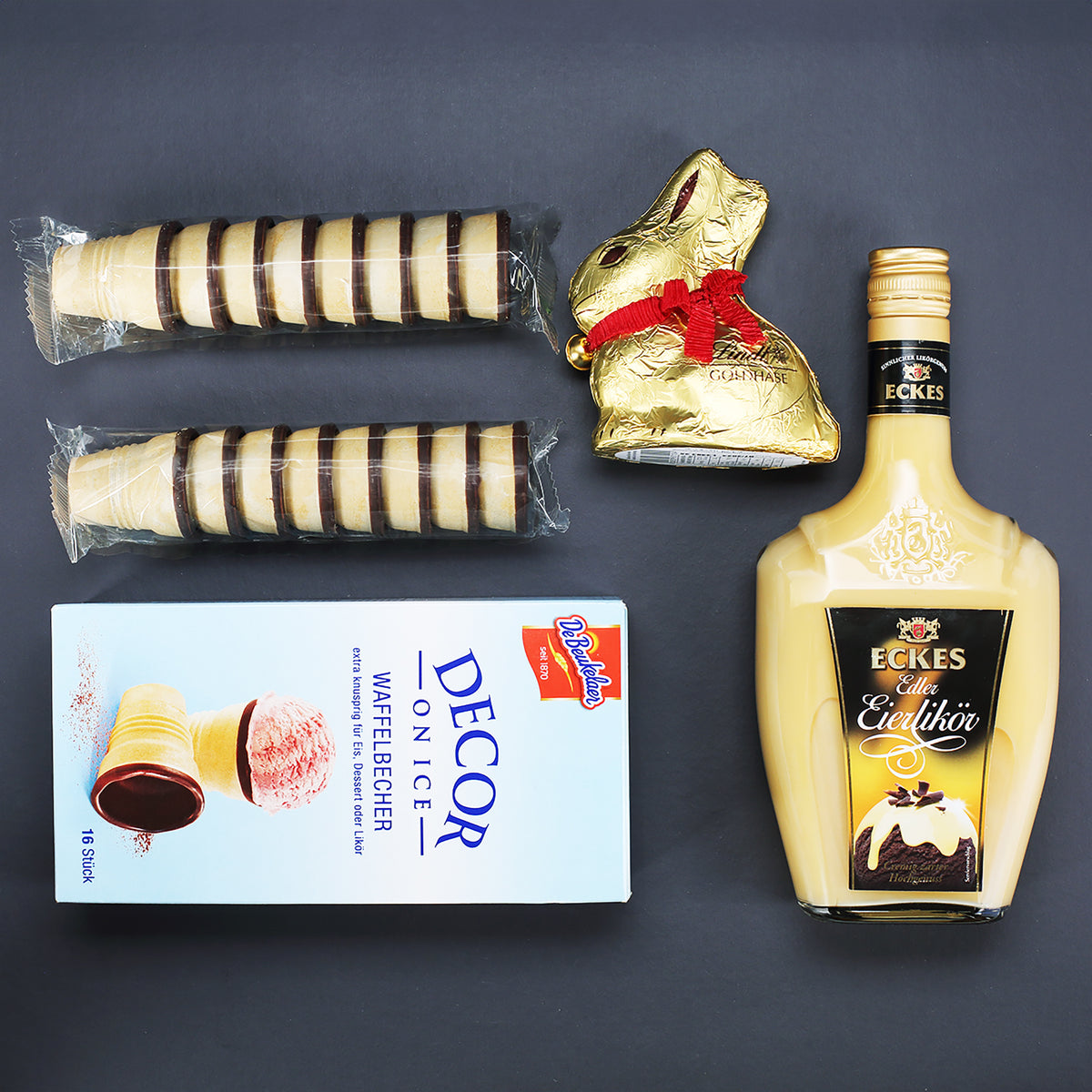 Geschenkset zu Ostern mit Eckes Eierlikör, Lindt Goldhase und Waffelbechern im bedruckten Pflanzkorb