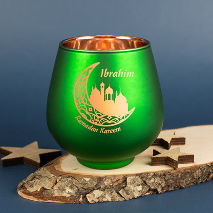 Grünes Ramadan-Windlicht mit Name „Ibrahim“ auf Holzdeko arrangiert