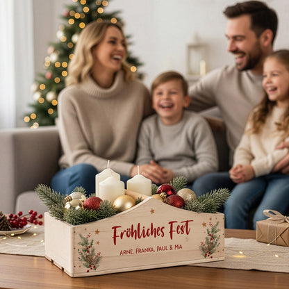 Dekorierter Weihnachtskorb mit Winterbouquet-Motiv auf Couchtisch, im Hintergrund lachende Familie vor dem Weihnachtsbaum.