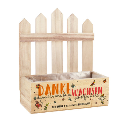 Leere Pflanzkiste mit Zaun, Text „Danke, dass ihr uns beim Wachsen geholfen habt“ und Personalisierung „von Hanna & Mia aus der Mäusegruppe“