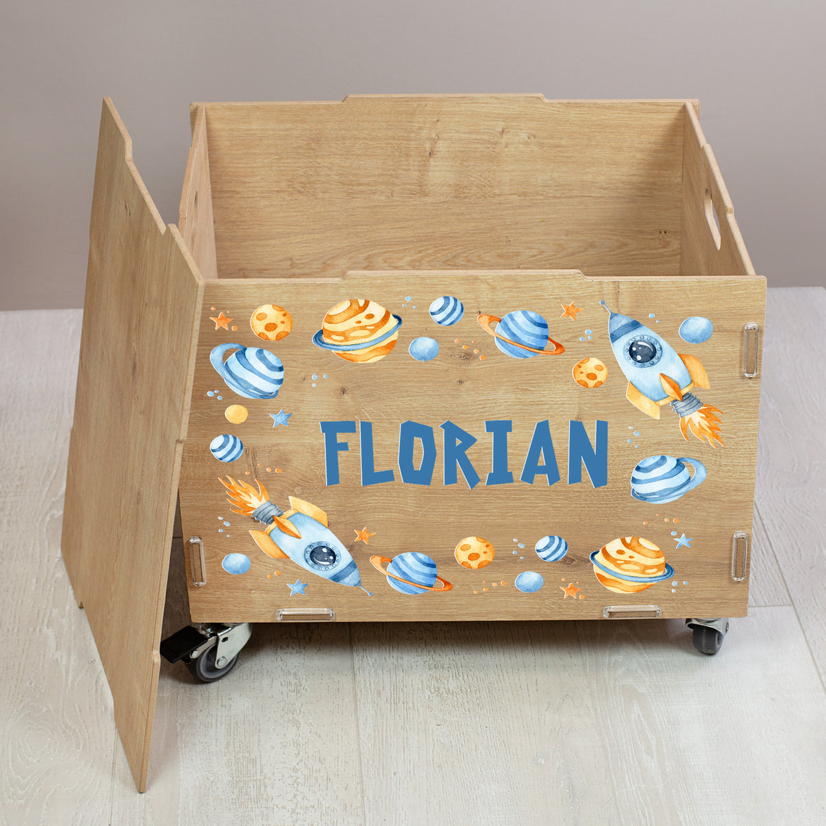 Offene Spielzeug-Rollkiste aus Holz mit Weltraum-Design, farbigen Planeten und Raketen, personalisiert mit Name Florian auf der Front
