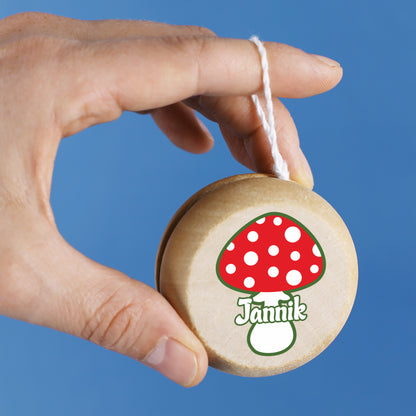 Nahaufnahme des Yo-Yos mit Pilzdesign, gut sichtbarer Namensdruck, gehalten von einer Hand