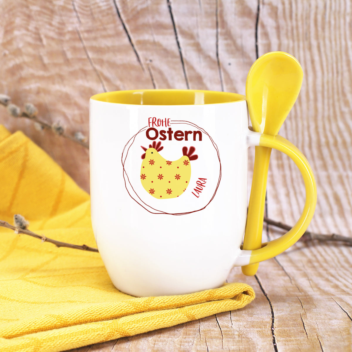 Personalisierte Ostertasse mit gelbem Löffel im Henkel, Huhn-Motiv und Name Laura auf gelber Serviette