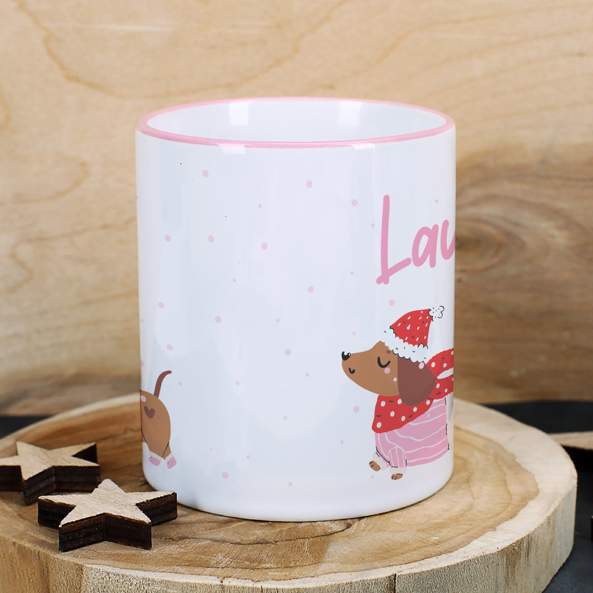 Detailansicht der personalisierten Dackel-Tasse auf Holzuntergrund mit winterlicher Dekoration