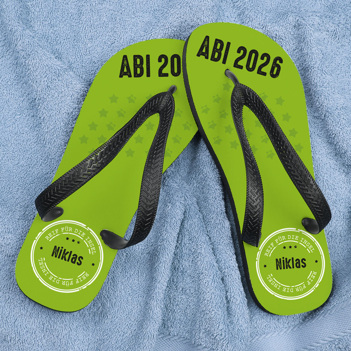 Abi Sandalen mit Name "Niklas" - Reif für die Insel - auf blauem Handtuch