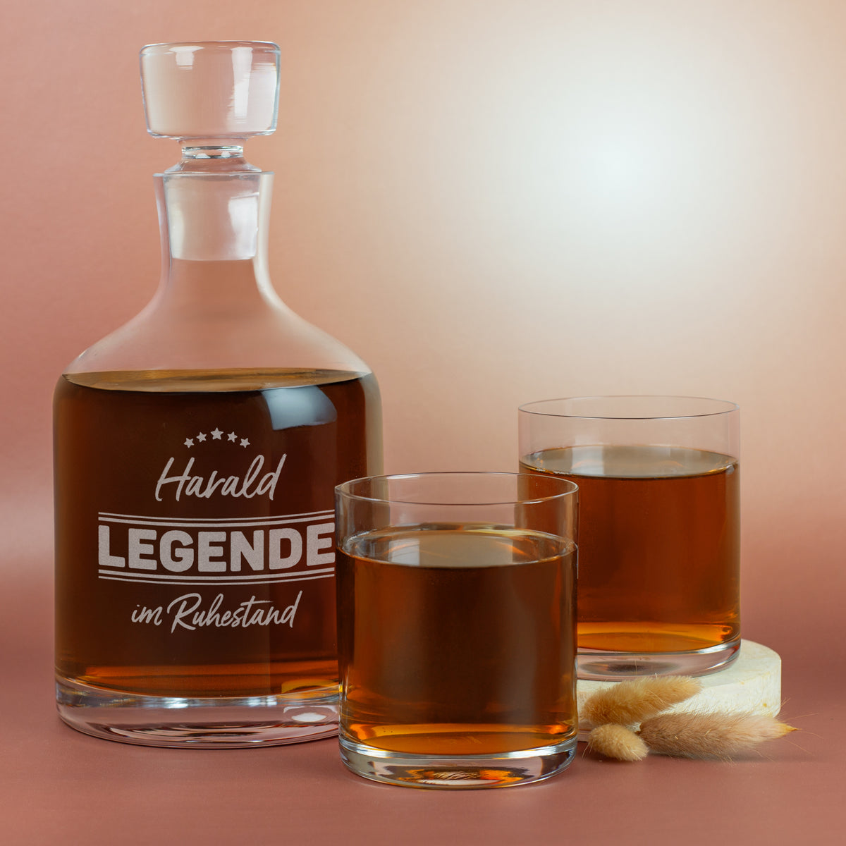 Personalisierte Whisky-Karaffe von Leonardo mit Gravur „Harald – Legende im Ruhestand“ zusammen mit zwei Whiskygläsern, gefüllt inszeniert.