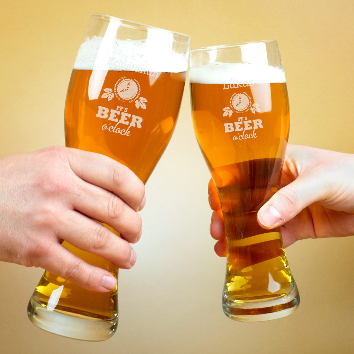 Zwei Personen stoßen mit gravierten Leonardo-Weizengläsern „It’s Beer o’clock“ an