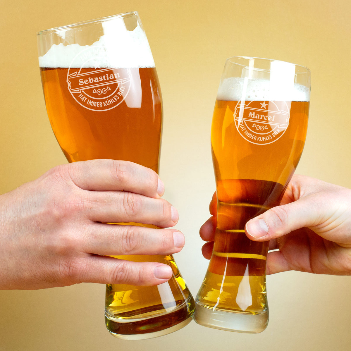 Zwei Personen stoßen mit gravierten Weizengläsern „Sebastian“ und „Marcel“ an, beide Gläser mit Bier gefüllt.