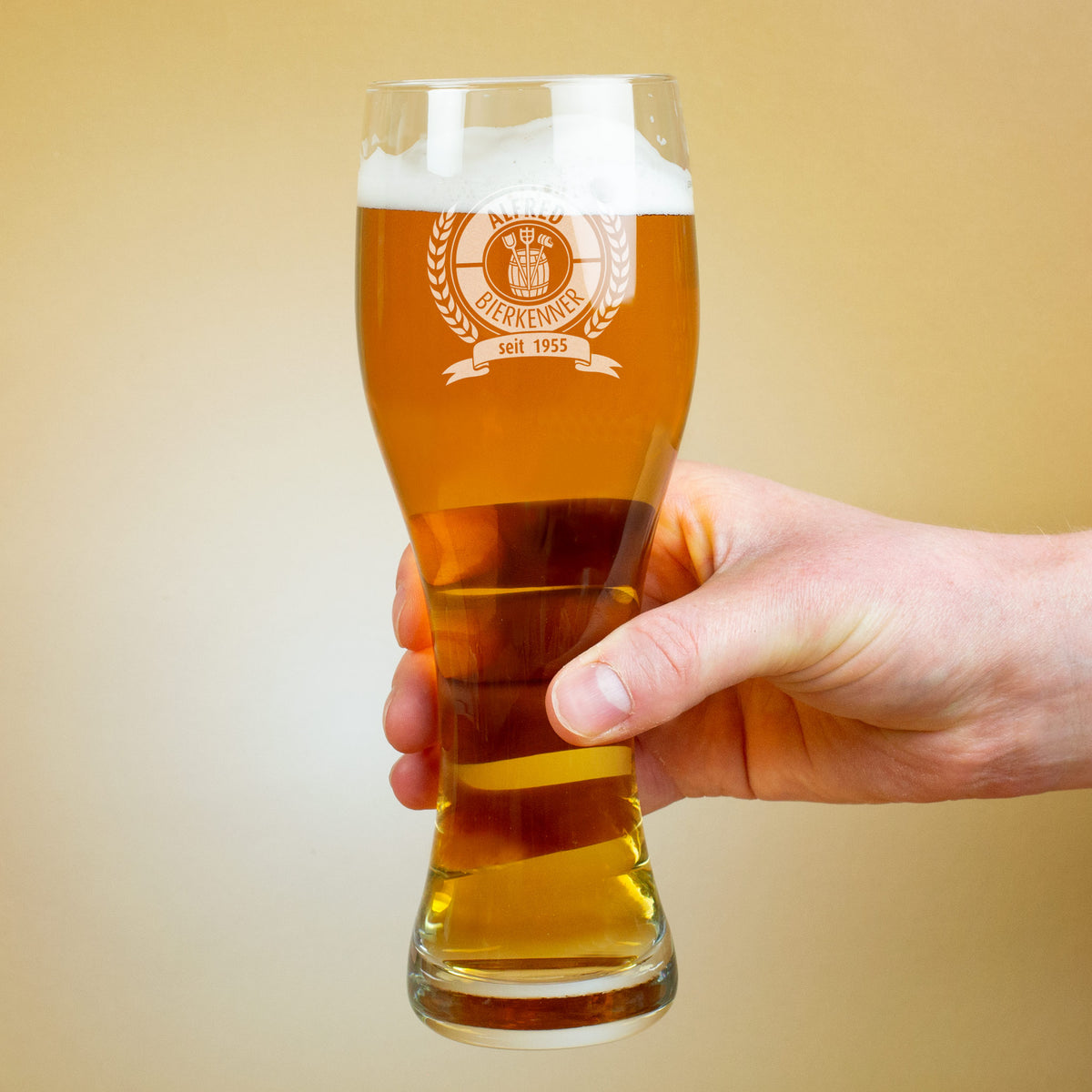 Hand hält graviertes Leonardo Bierglas mit Schaumkrone, Gravur „Bierkenner seit 1955“ sichtbar