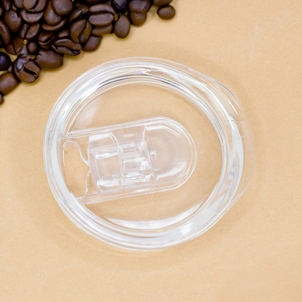 Transparenter Deckel des Thermobechers, liegend neben Kaffeebohnen