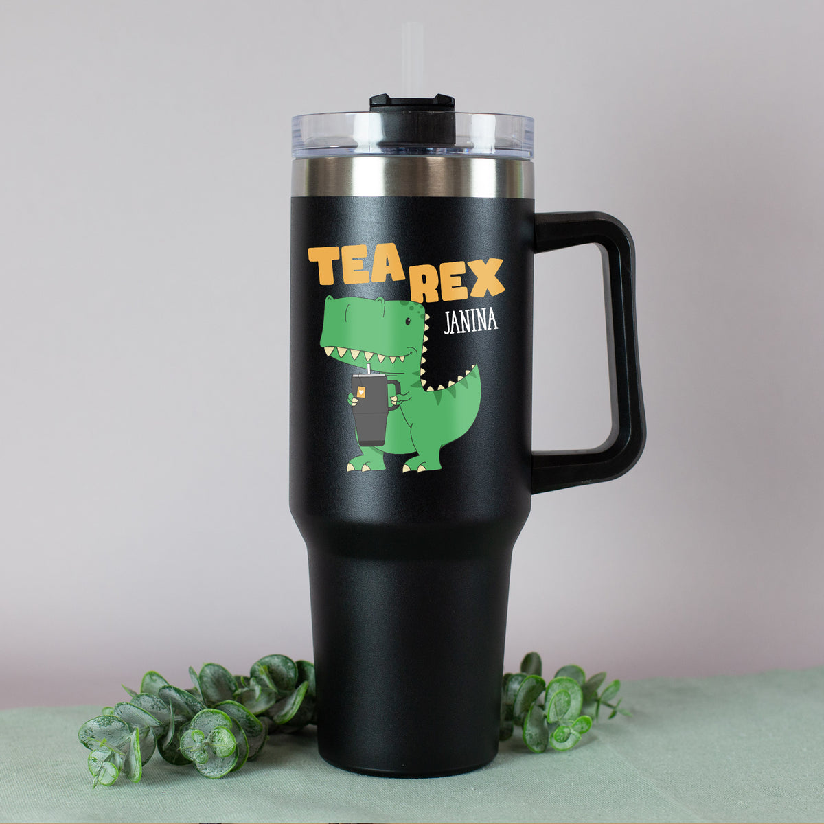 Detailansicht: T-Rex hält einen Becher, darüber der orangene Schriftzug