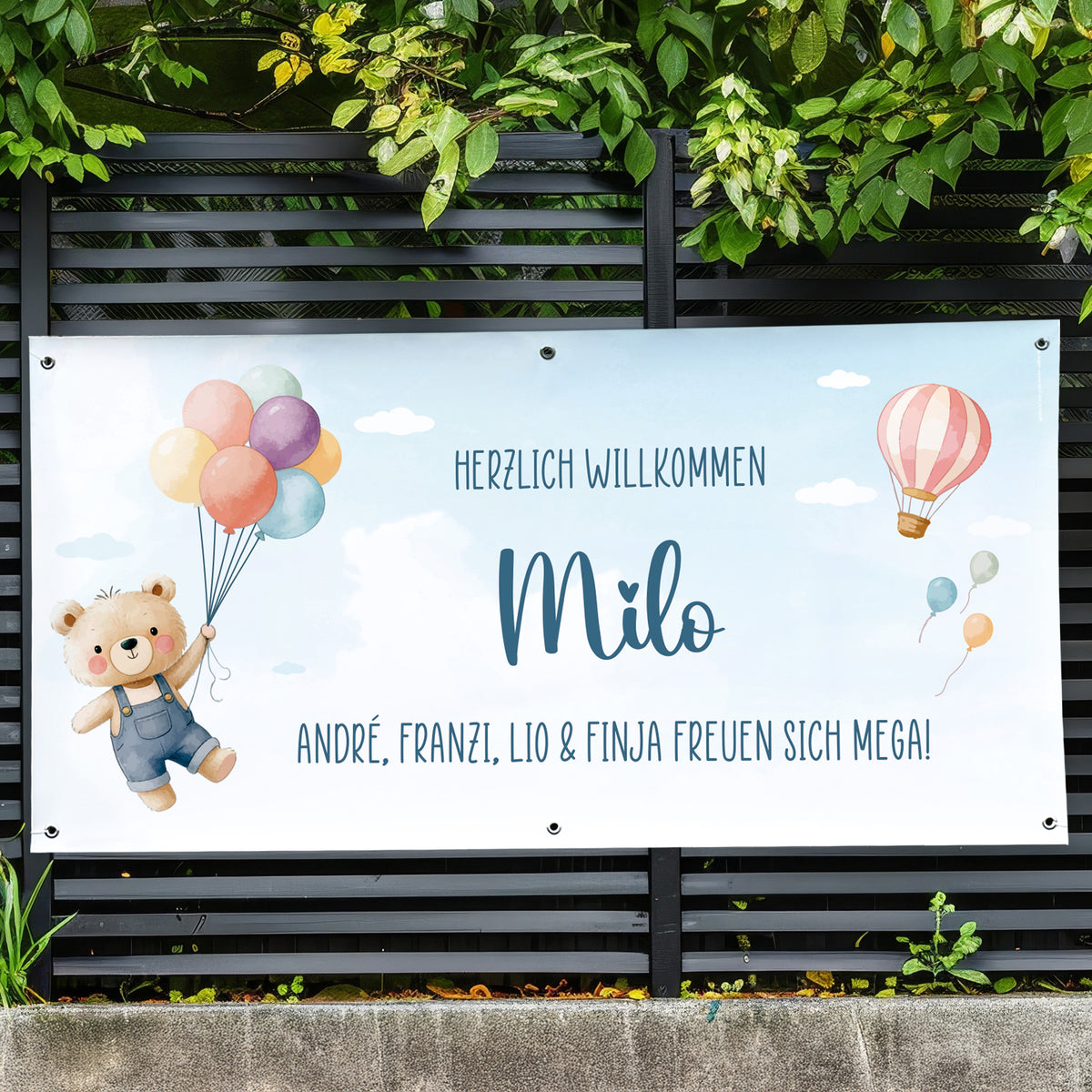 Personalisiertes Banner zur Geburt mit Name Milo und Wunschtext „André, Franzi, Lio & Finja freuen sich mega“ am Gartenzaun