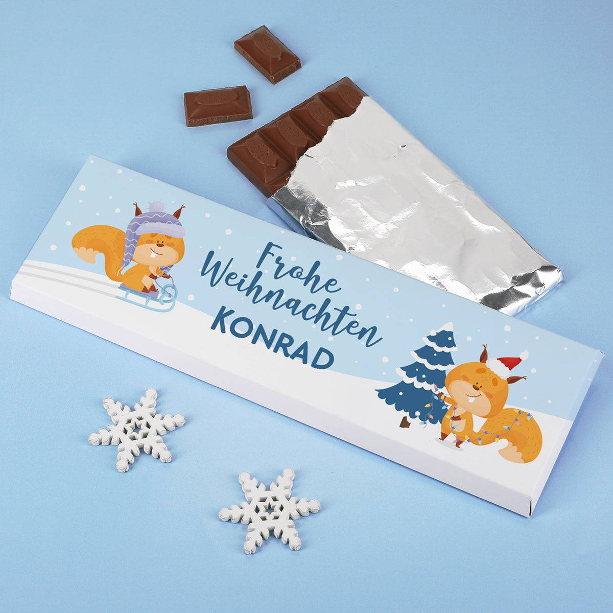 Weihnachtsschokolade mit Eichhörnchen und Name Konrad auf personalisierter Verpackung mit Schneeflocken.