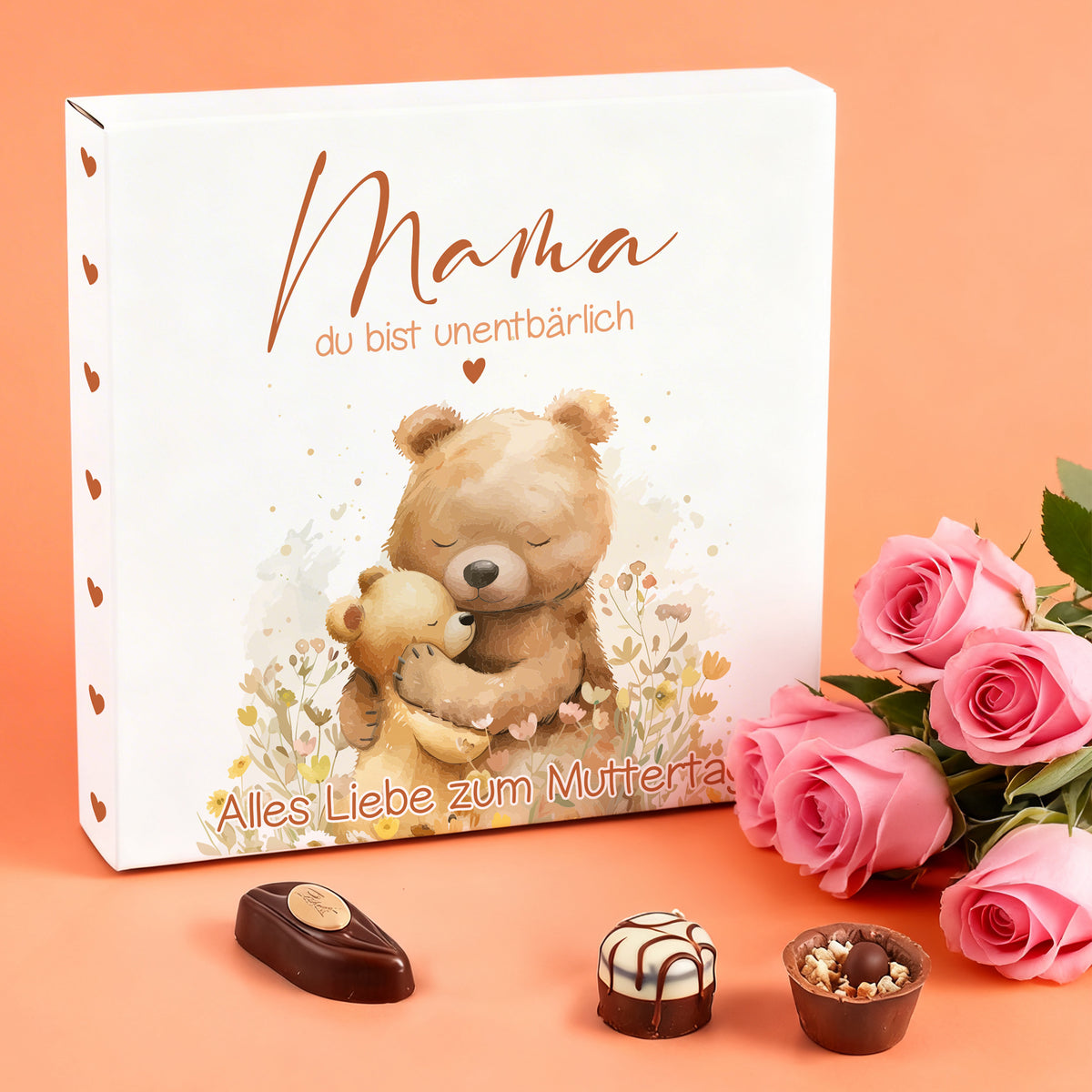 Muttertags Pralinenbox mit Bärenmotiv und Schriftzug „Mama du bist unentbärlich“ neben Rosen dekoriert
