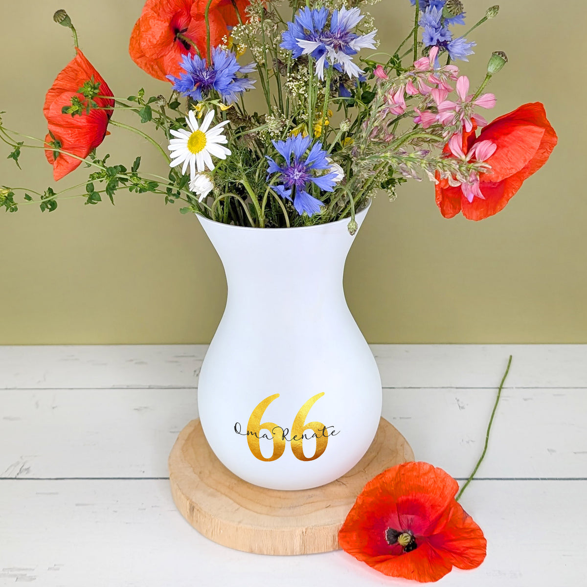 Vase in Weiß mit Blumenstrauß – dekorativ auf Tisch platziert