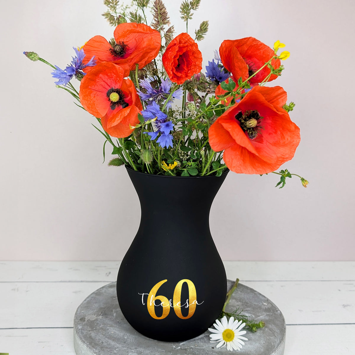 Vase in Schwarz mit Blumenstrauß – dekorativ auf Tisch platziert