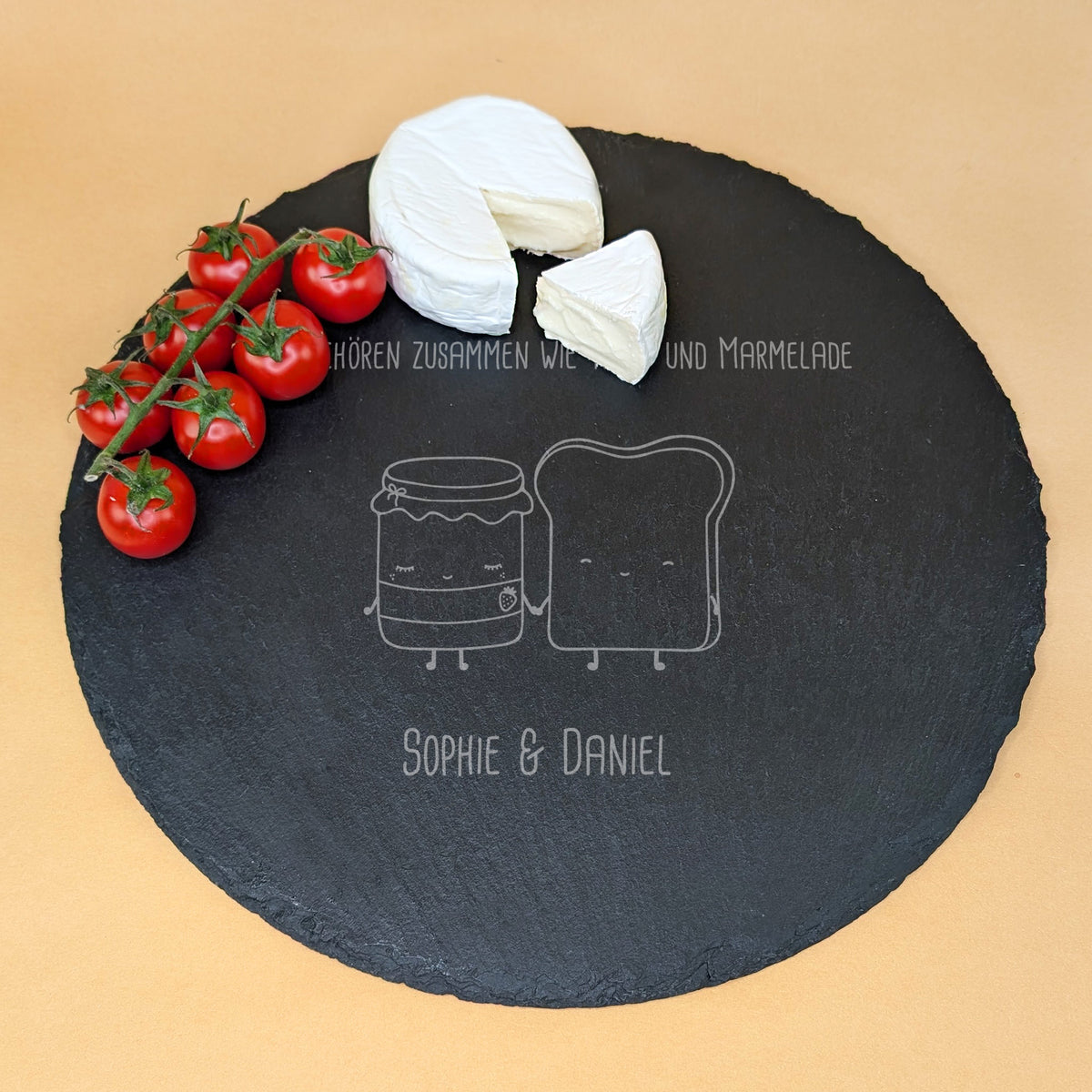 Runde Schieferplatte mit Gravur „Wir gehören zusammen wie Toast und Marmelade“ und zwei Namen, serviert mit Camembert und Tomaten