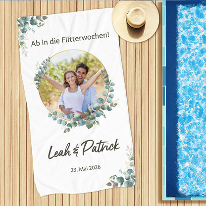 Hochzeits-Handtuch mit Eukalyptus-Motiv, personalisiert mit Foto, Namen und Wunschtext – am Pool ausgebreitet.