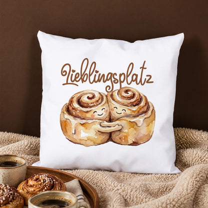 Weißes Kuschelkissen mit Zimtschnecken Pärchen und Schriftzug Lieblingsplatz