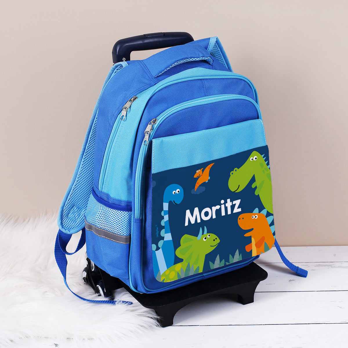 Kindertrolley mit Dino Motiv und Name bedruckt auf weißem Teppich