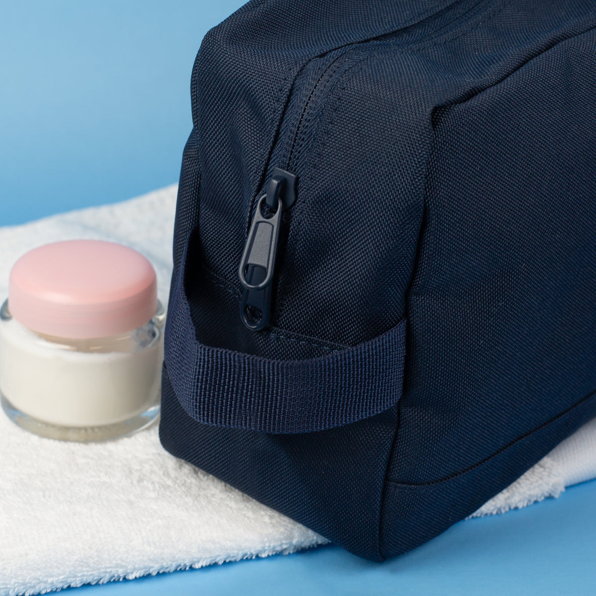 Detailansicht der dunkelblauen Waschtasche mit stabilem Reißverschluss und seitlicher Trageschlaufe