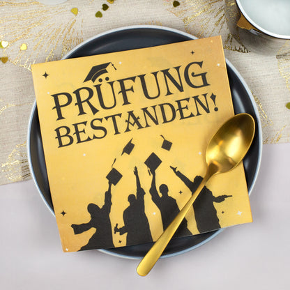 Goldene Servietten Prüfung bestanden auf einem Teller mit goldfarbenem Löffel – Schulabschluss, Abitur oder Studium