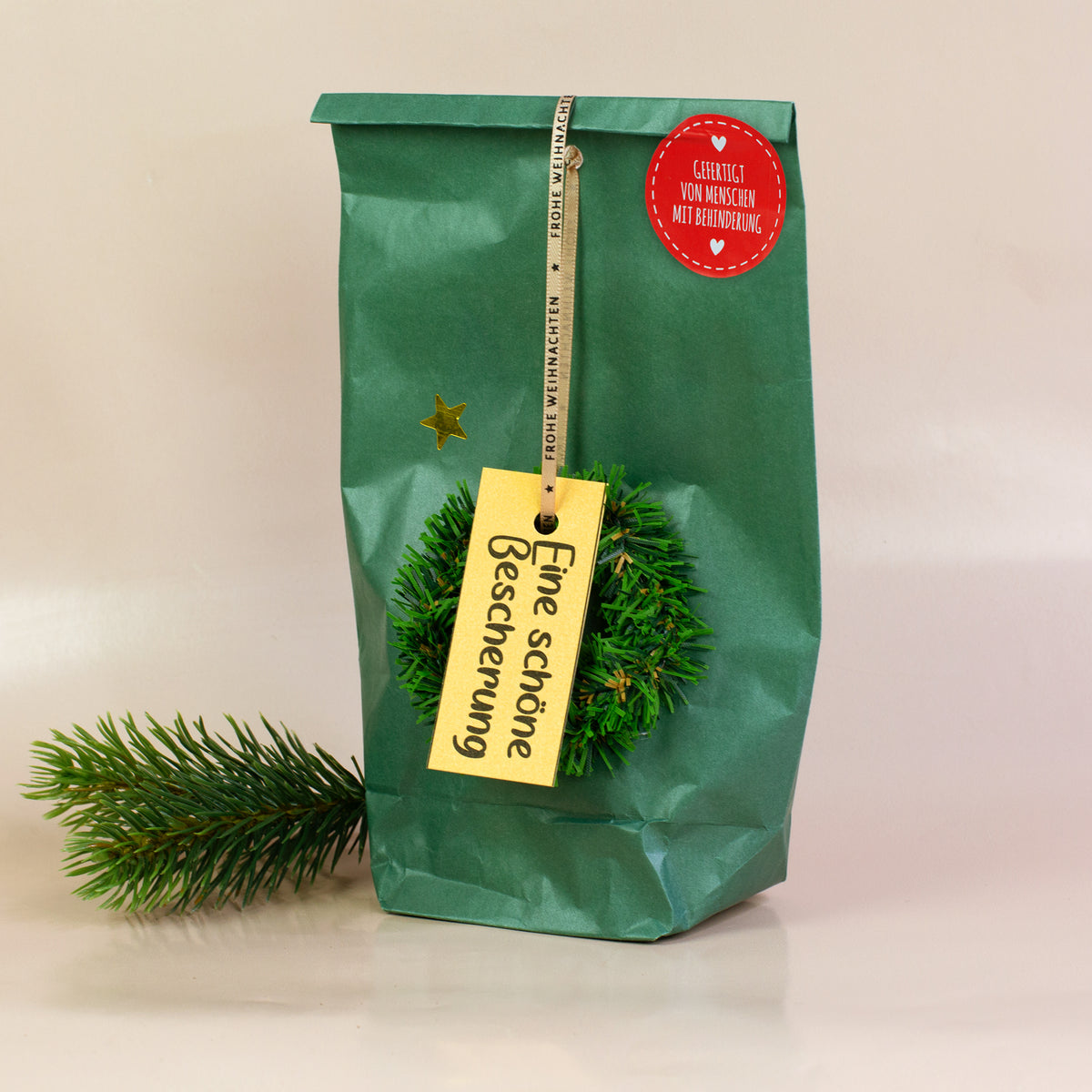 Wundertüte „Eine schöne Bescherung“ mit grünem Papier, Deko-Kranz und Geschenkanhänger